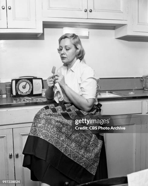 Singer and composer Mrs. Gwyn Steinbeck in her kitchen washing dishes while listening to the radio. She is the ex-wife of the novelist, John...