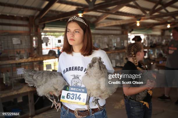 Kameryn Warren, the 2018 Iowa Poultry Princess, carries her chickens in to be judged at the Iowa County Fair on July 12, 2018 in Marengo, Iowa. The...