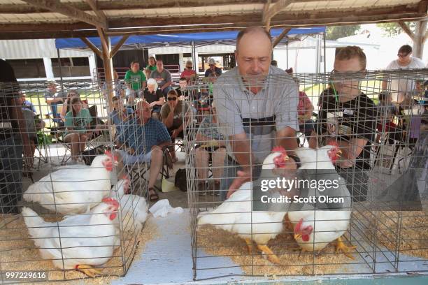 Glenn Drowns judges chickens at the Iowa County Fair on July 12, 2018 in Marengo, Iowa. The fair, like many in counties throughout the Midwest, helps...