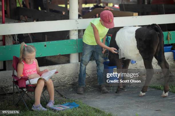 Evan Koehn prepares his calf for judging while his sister Abby sits nearby at the Iowa County Fair on July 12, 2018 in Marengo, Iowa. The fair, like...