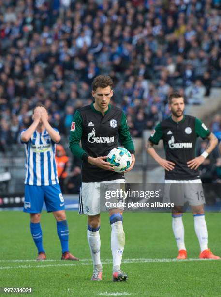 Schalke's Leon Goretzka walks with the ball in hands towards the penalty point as Berlin's Vladimir Darida folds his hands over his face during the...