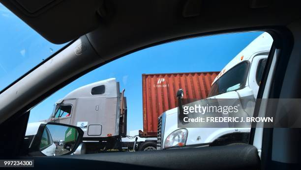 Container delivery trucks make their way south on the 710 freeway heading to the Port of Long Beach on July 12, 2018 in Long Beach, California, one...