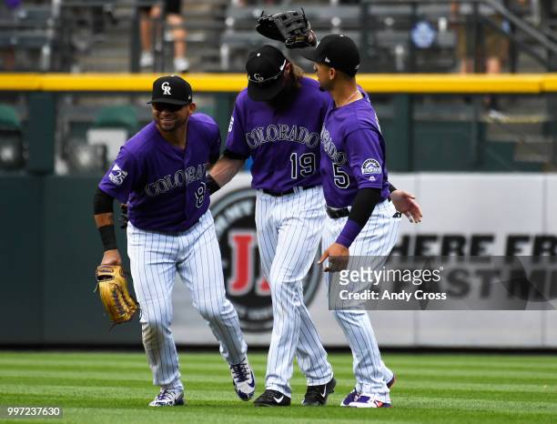 Colorado Rockies left fielder Gerardo Parra, and teammates Charlie Blackmon, center, and Carlos Gonzalez celebrate in the outfield after defeating...