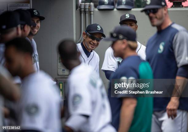 Ichiro Suzuki of the Seattle Mariners peaks around from the entrance of the clubhouse into the dugout before a game against the Colorado Rockies at...