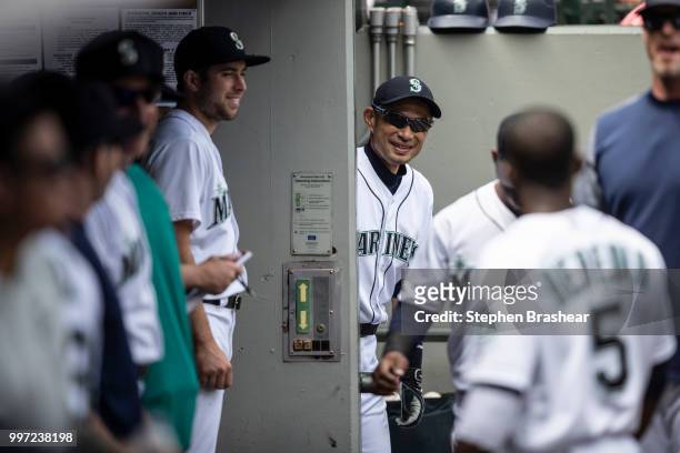 Ichiro Suzuki of the Seattle Mariners jokes with teammates from the entrance of the clubhouse before a game against the Colorado Rockies at Safeco...