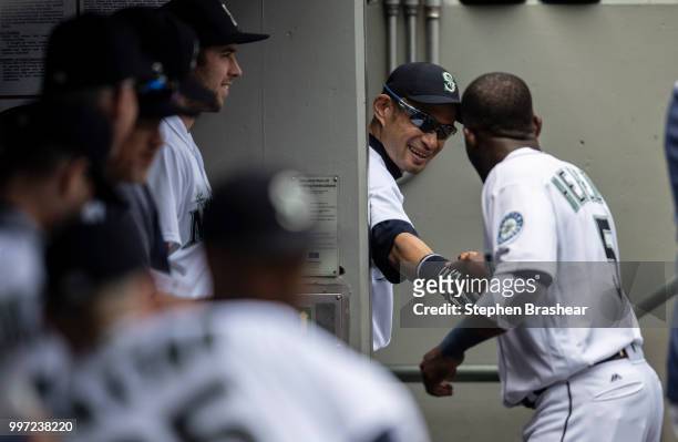 Ichiro Suzuki of the Seattle Mariners shakes hands with Guillermo Heredia of the Seattle Mariners from the entrance to the clubhouse before a game...