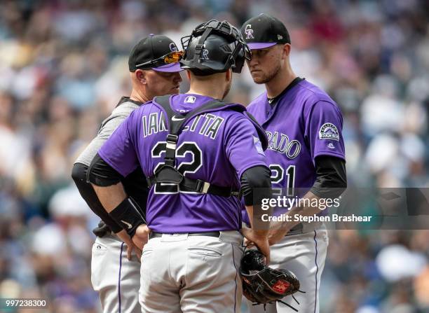 Colorado Rockies pitching coach Steve Foster, catcher Chris Iannetta and starting pitcher Kyle Freeland of the Colorado Rockies meet at the pitcher's...