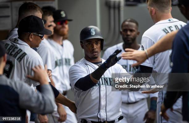 Jean Segura of the Seattle Mariners is congratulated by teammates in the dugout after hitting home run during a game against the Colorado Rockies at...