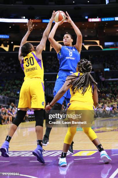 Elizabeth Cambage of the Dallas Wings handles the ball against Nneka Ogwumike and Chelsea Gray of the Los Angeles Sparks during a WNBA basketball...