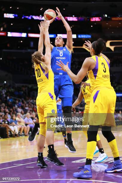 Elizabeth Cambage of the Dallas Wings handles the ball against Maria Vadeeva and Candace Parker of the Los Angeles Sparks during a WNBA basketball...