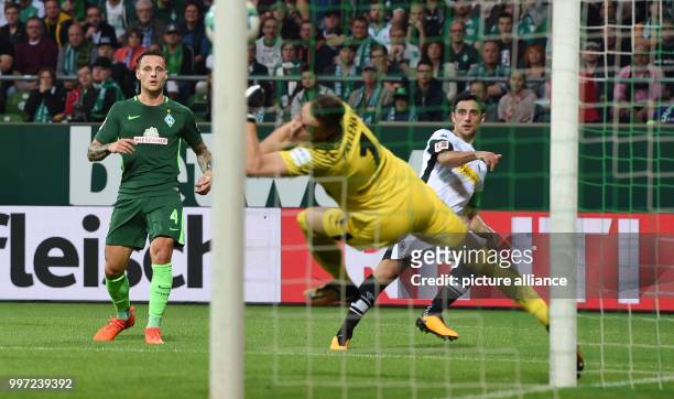 Gladbach's Lars Stindl scores against Werder goalie Jiri Pavlenka and Robert Bauer to make it 0:1 during the German Bundesliga football match between...