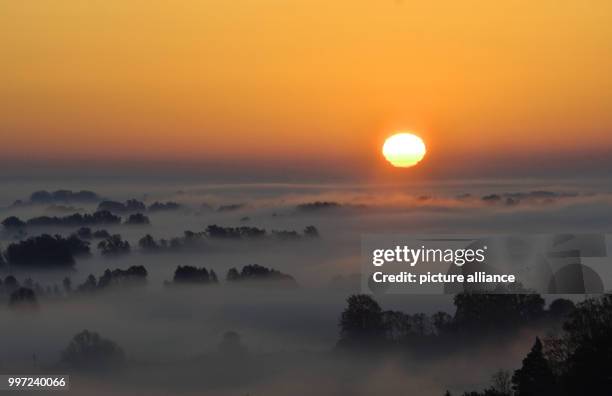 Dpatop - The sun rises over a foggy valley in Niederfinow, Germany, 16 October 2017. Photo: Paul Zinken/dpa