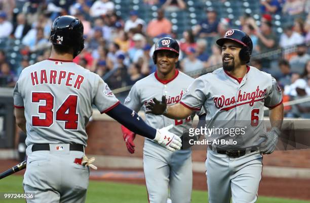 Anthony Rendon of the Washington Nationals celebrates his two run home run against the New York Mets in the first inning with Bryce Harper during...