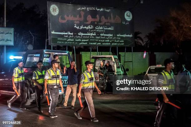 Egyptian policemen stand guard outside Heliopolis petrochemical company after a strong explosion occurred in a chemical tank near the Cairo airport...