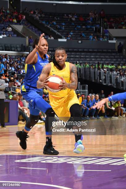 Riquna Williams of the Los Angeles Sparks handles the ball against Azura Stevens of the Dallas Wings on July 12, 2018 at STAPLES Center in Los...