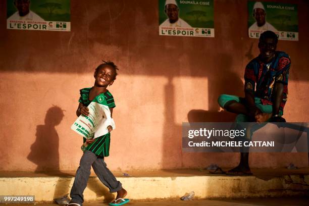 Young girl holds a poster for Malian opposition candidate for the presidential elections Soumaila Cisse during a rally in Koulikoro on July 12, 2018....