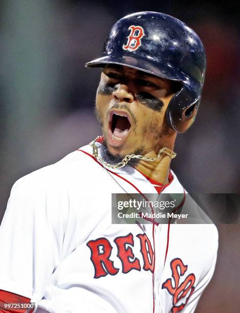 Mookie Betts of the Boston Red Sox celebrates after hitting a grand slam against the Toronto Blue Jays during the fourth inning at Fenway Park on...