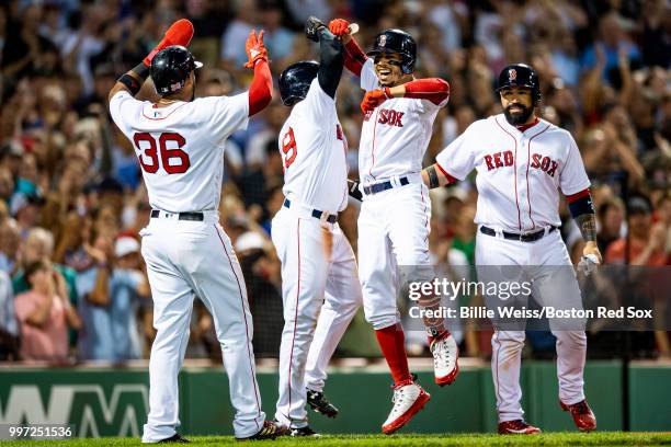 Mookie Betts of the Boston Red Sox reacts with Eduardo Nunez, Jackie Bradley Jr. #19, and Sandy Leon after hitting a grand slam home run during the...
