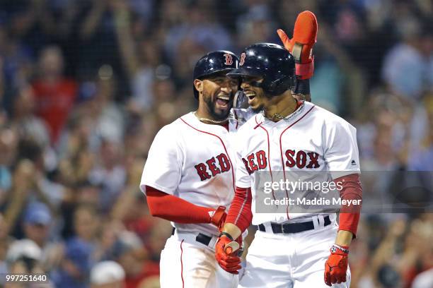 Eduardo Nunez of the Boston Red Sox congratulates Mookie Betts after he hit a grand slam against the Toronto Blue Jays during the fourth inning at...