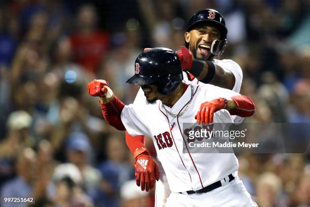 Eduardo Nunez of the Boston Red Sox congratulates Mookie Betts after he hit a grand slam against the Toronto Blue Jays during the fourth inning at...