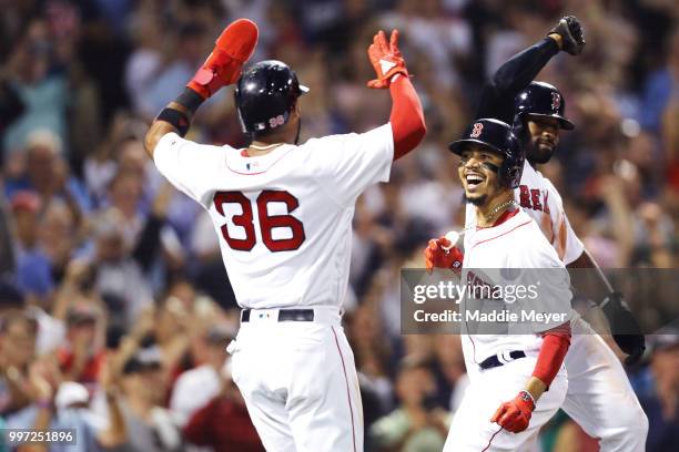 Mookie Betts of the Boston Red Sox celebrates with Eduardo Nunez and Jackie Bradley Jr. #19 after hitting a grand slam against the Toronto Blue Jays...