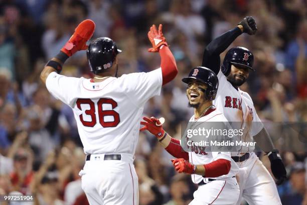 Mookie Betts of the Boston Red Sox celebrates with Eduardo Nunez and Jackie Bradley Jr. #19 after hitting a grand slam against the Toronto Blue Jays...