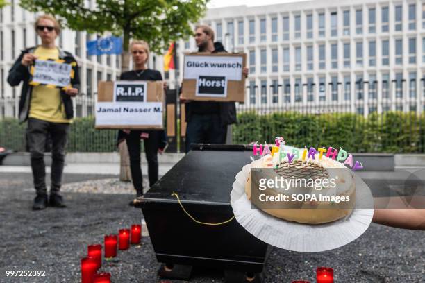 An activist seen holding a birthday cake for Horst Seehofer. Activists protest in front of the Federal Ministry of Interior during the vigil for the...