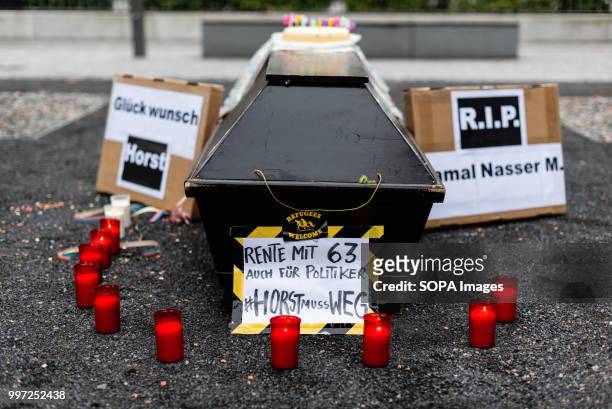 Coffin, birthday cake, posters , candles are seen laying on the ground. Activists protest in front of the Federal Ministry of Interior during the...