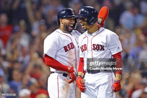 Mookie Betts of the Boston Red Sox celebrates with Eduardo Nunez after hitting a grand slam against the Toronto Blue Jays during the fourth inning at...