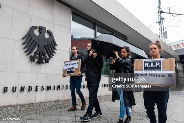 Activists seen carrying a coffin and posters. Activists protest in front of the Federal Ministry of Interior during the vigil for the Afghan refugee...