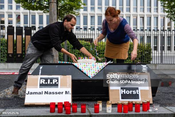 Activists seen placing a birthday cake for Horst Seehofer on a coffin. Activists protest in front of the Federal Ministry of Interior during the...