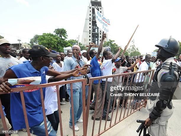 Haitians face riot police as they demonstrate near the presidential palace in Port-au-Prince on May 17, 2010 against President Rene Preval's decision...