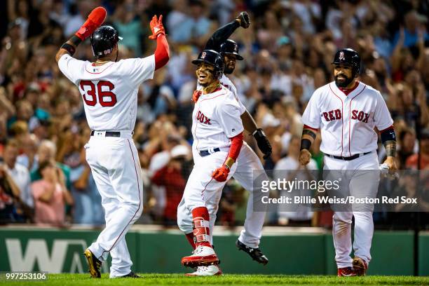 Mookie Betts of the Boston Red Sox reacts with Eduardo Nunez, Jackie Bradley Jr. #19, and Sandy Leon after hitting a grand slam home run during the...