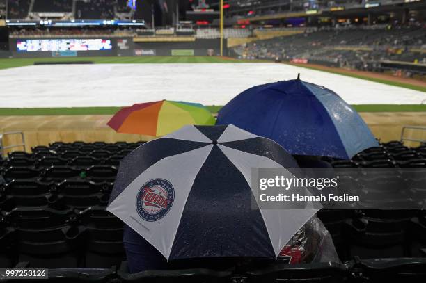 Fans wait out a rain delay before the game between the Minnesota Twins and the Tampa Bay Rays on July 12, 2018 at Target Field in Minneapolis,...
