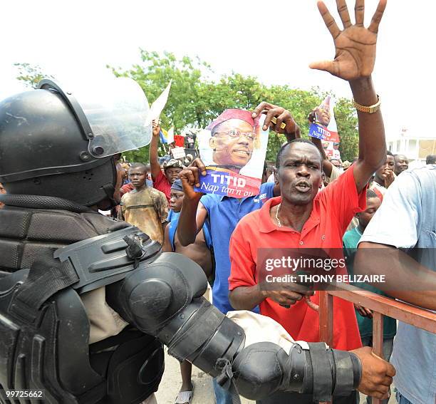 Haitians march past riot police as they demonstrate near the presidential palace in Port-au-Prince on May 17, 2010 against President Rene Preval's...