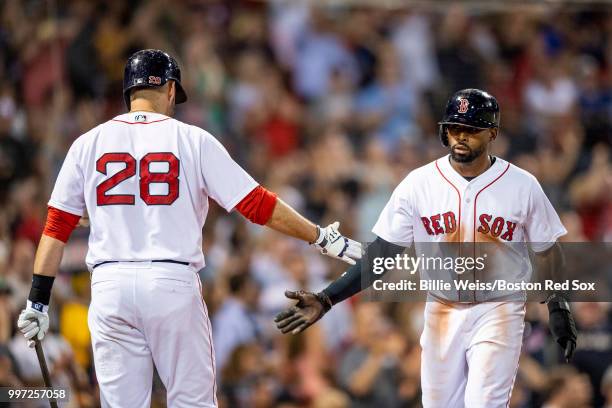 Jackie Bradley Jr. #19 of the Boston Red Sox high fives J.D. Martinez after scoring during the seventh inning of a game against the Toronto Blue Jays...