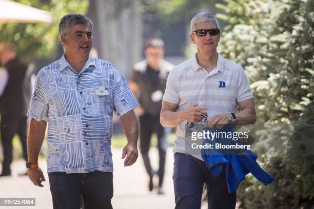 Eddy Cue, senior vice president of internet software and services at Apple Inc., left, and Tim Cook, chief executive officer of Apple Inc., walk the...