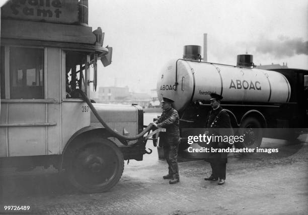 To save time, buses are beinig filled with fuel. Photograph. Around 1930