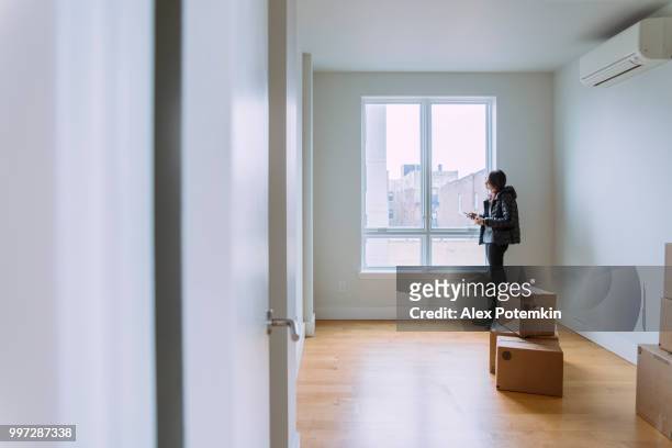 teenager girls, sisters, looking around the new empty apartment - alex potemkin or krakozawr stock pictures, royalty-free photos & images