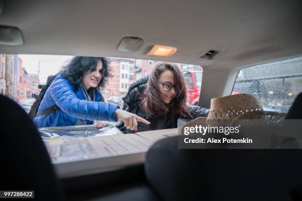 la mujer y su hija, adolescente chica, descargas cajas del baúl de un automóvil. mudanza en el apartamento nuevo. - alex potemkin or krakozawr fotografías e imágenes de stock