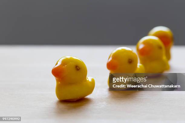 deletable imitation fruits in duck shape on wooden block - wooden block stockfoto's en -beelden