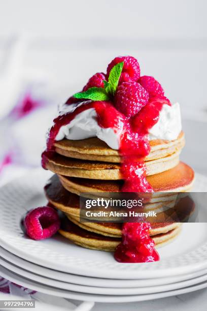 pancakes with raspberry sauce on white background - raspberry sauce stock pictures, royalty-free photos & images