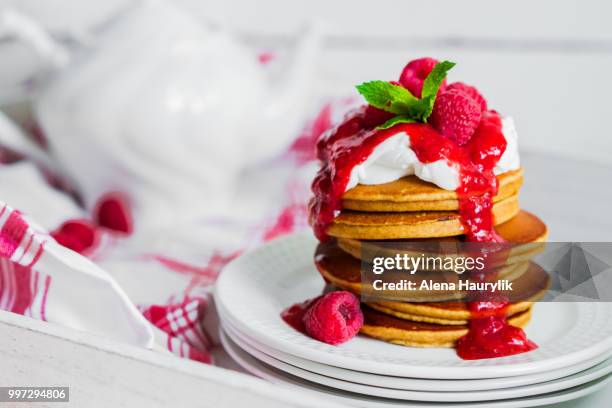 pancakes with raspberry sauce on white background - raspberry sauce stock pictures, royalty-free photos & images
