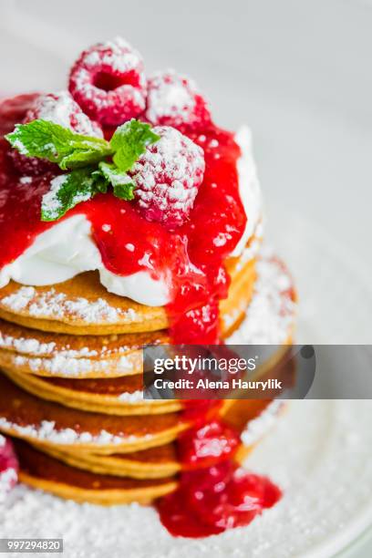 pancakes with raspberry sauce on white background - raspberry sauce stock pictures, royalty-free photos & images