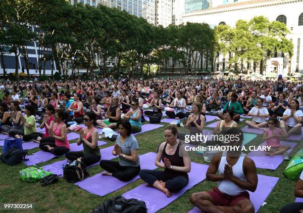People participate in an outdoor yoga event in Bryant Park in New York City July 12, 2018.