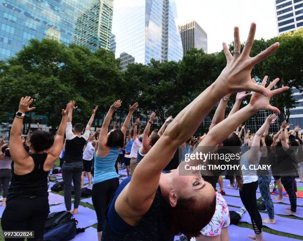 People participate in a free outdoor yoga event in Bryant Park in New York City July 12, 2018.