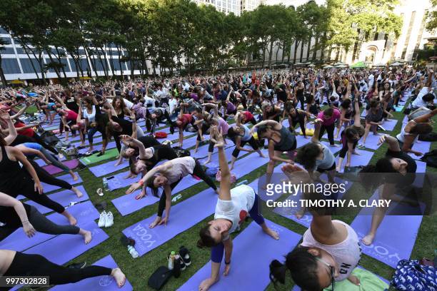 People participate in a free outdoor yoga event in Bryant Park in New York City July 12, 2018.