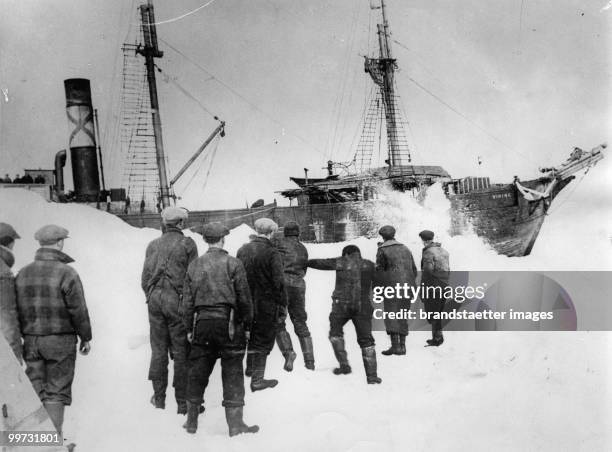 Crew mebers of the sealing-ship 'Viking' are blasting away the ice during a trip to the Arctic to make a passage for the ship. Photograph. Before...