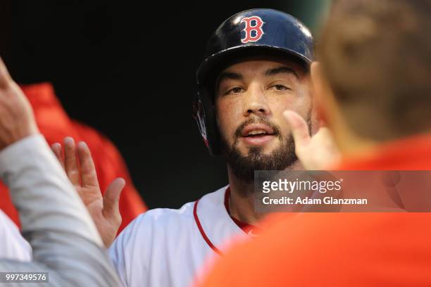 Blake Swihart of the Boston Red Sox returns to the dugout after scoring in the third inning of a game against the Texas Rangers at Fenway Park on...
