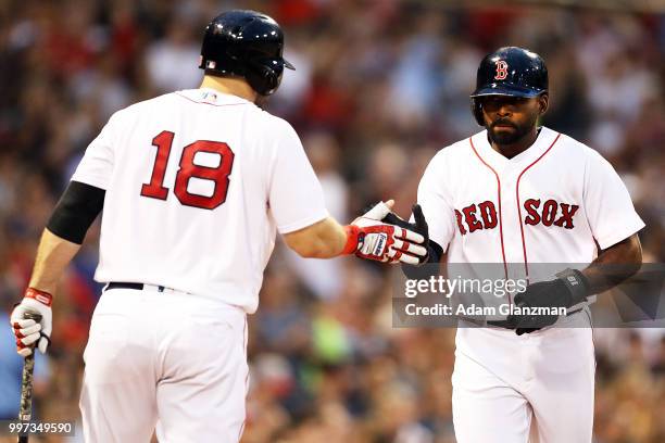 Jackie Bradley Jr. #19 high fives Mitch Moreland of the Boston Red Sox as he returns to the dugout after scoring in the third inning of a game...